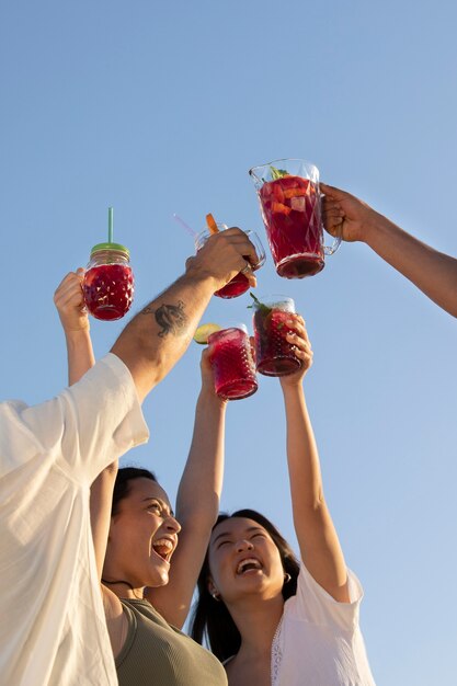 Amigos tendo uma festa de sangria na praia