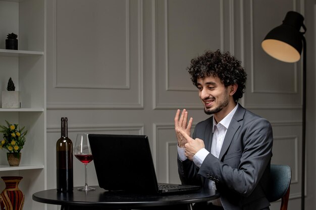 Amor virtual bonitão bonito de terno com vinho em um encontro de computador à distância mostrando o anel no dedo