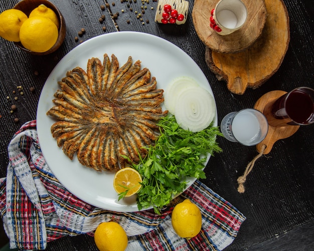 Foto grátis anchovas fritas com limão e ervas.