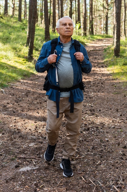 Ancião fazendo mochila na natureza