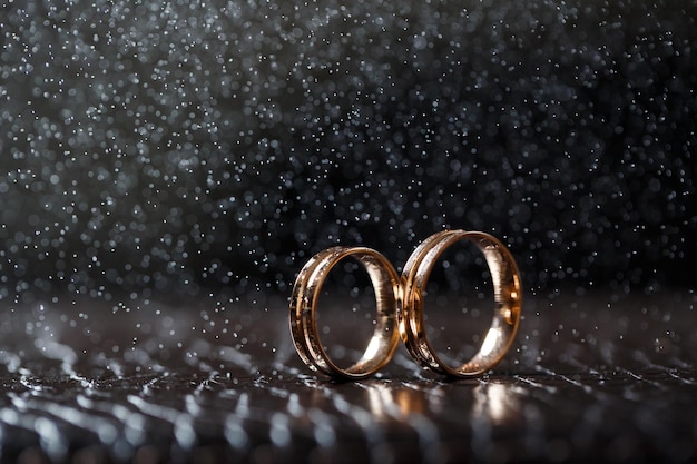 Anéis de casamento com gotas de água,o conjunto de anéis de noivado.,belo fundo prateado com anéis de casamento e estrelas Foto Premium
