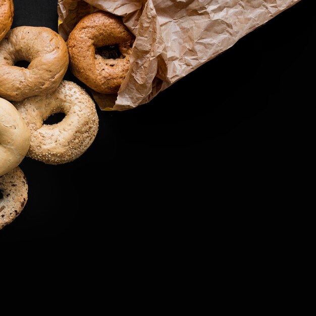 Anéis de pão acabado de cozer contra o fundo preto