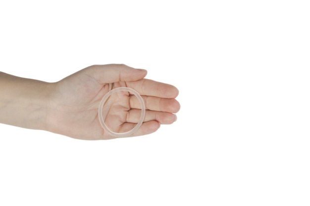 Anel anticoncepcional na mão de uma mulher isolado no fundo branco anel vaginal para uso anticoncepcional
