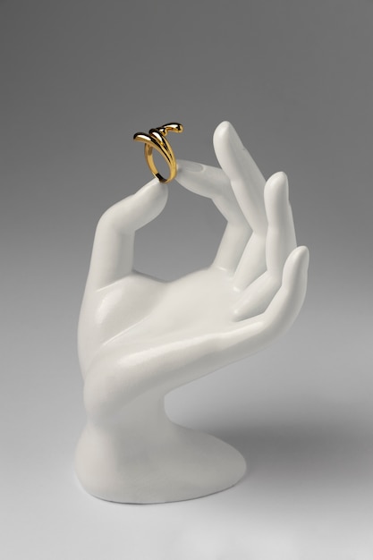 Anel de ouro caro com exibição de suporte de mão humana
