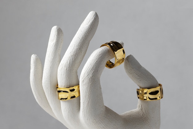 Anel de ouro caro com exibição de suporte de mão humana