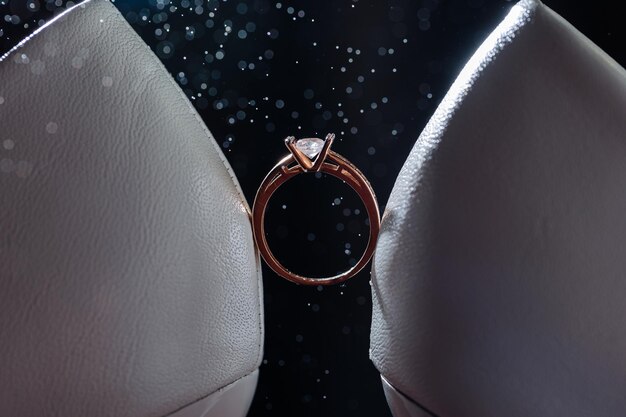 Anel de ouro da noiva com uma pedra entre sapatos brancos com saltos anel precioso da noiva