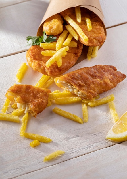 Ângulo alto de prato de peixe e batatas fritas em cone de papel
