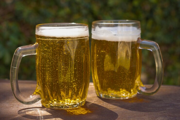 Foto grátis ângulo baixo duas canecas com cerveja fresca