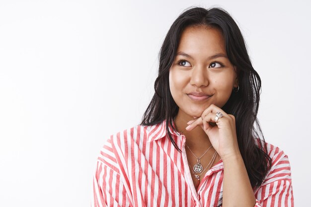 Animador feminino sonhador e criativo pensando em novas ideias, sonhando acordado como comemorar o dia dos namorados com o namorado amoroso olhando para o canto superior esquerdo, sorrindo sensualmente e tocando a bochecha