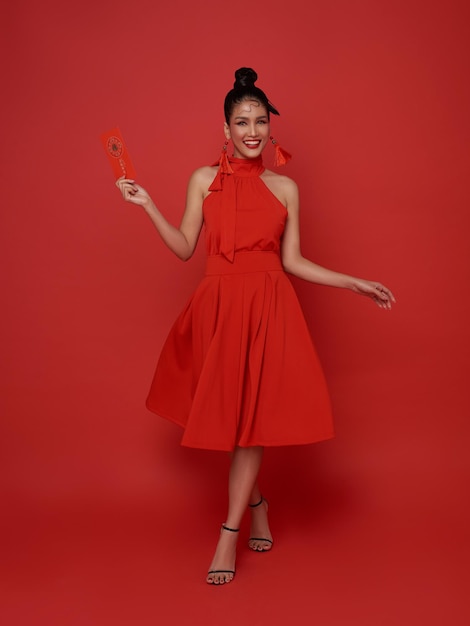 Foto grátis ano novo chinês homem asiático segurando angpao ou pacote vermelho presente monetário isolado em fundo vermelho