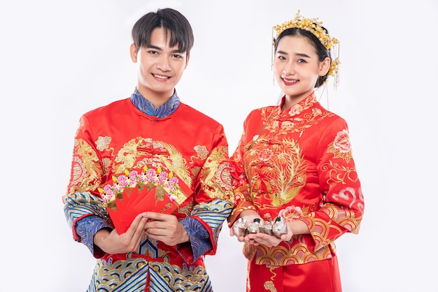 Ano novo chinês, homem e mulher usam cheongsam dão dinheiro como presente para o tradicional