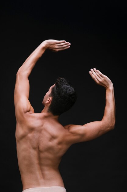 Anónimo masculino dançando com os braços erguidos