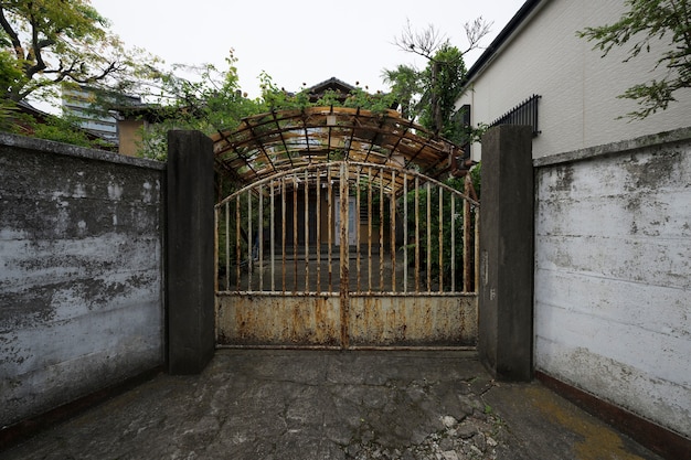 Antiga casa abandonada com portão enferrujado