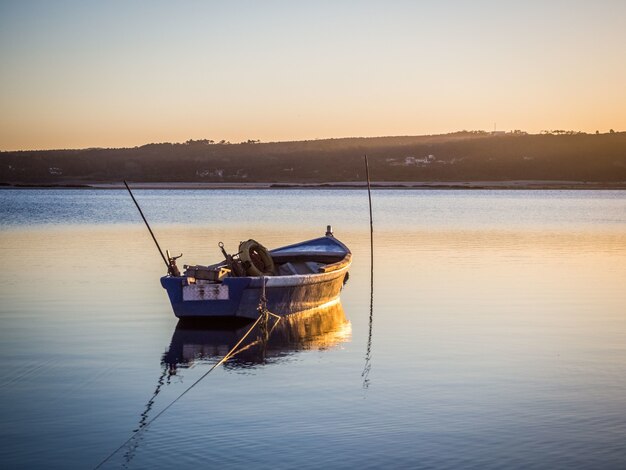 Antigo barco de pesca no rio com vista deslumbrante do pôr do sol