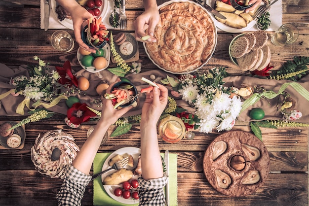 Apartamento-festa de amigos ou família na mesa festiva com carne de coelho, legumes, tortas, ovos, vista superior.