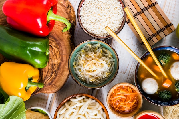 Foto grátis apartamento leigos de comida tailandesa deliciosa com pimentões coloridos em tronco de árvore