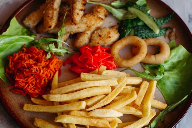 Foto grátis aperitivos saborosos para grande companhia de amigos bebendo cerveja nuggets de frango dourado batatas fritas salada verde folhas e pepinos frescos em pé na mesa branca parecendo delicioso de dar água na boca