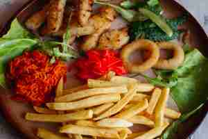 Foto grátis aperitivos saborosos para grande companhia de amigos bebendo cerveja nuggets de frango dourado batatas fritas salada verde folhas e pepinos frescos em pé na mesa branca parecendo delicioso de dar água na boca