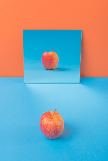 Apple na mesa azul isolada na laranja