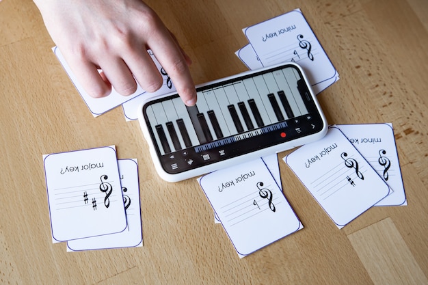 Foto grátis aprenda teoria musical, solfejo e partituras com o aplicativo de piano em seu telefone e flashcards educacionais
