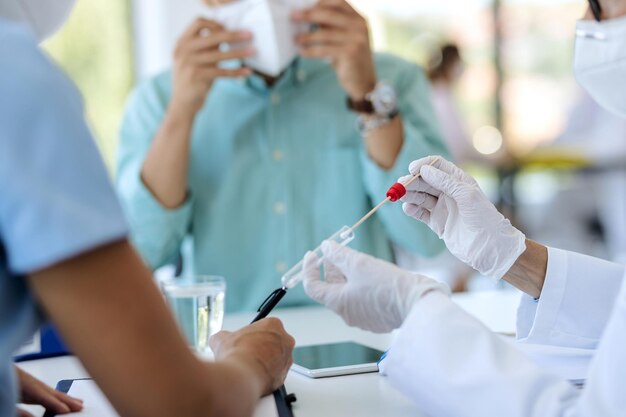 Aproximação do profissional de saúde fazendo teste de PCR de um paciente na clínica