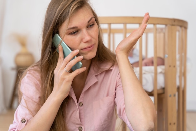 Foto grátis aproxime-se da mãe cansada falando ao telefone