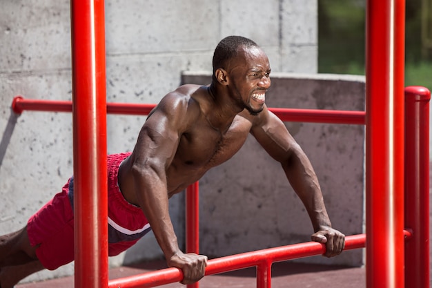 apto atleta fazendo exercícios no estádio. Homem afro-americano ao ar livre na cidade