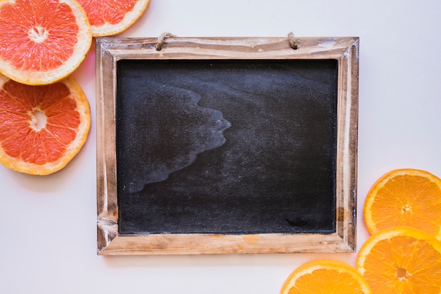 Ardósia em branco com fatias de toranja e laranja