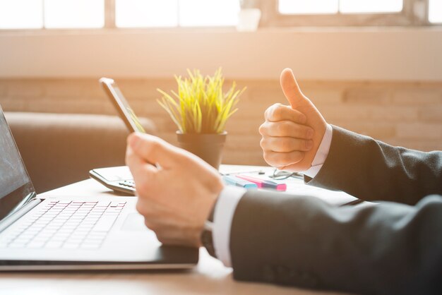 Área de trabalho de escritório com laptop e um homem de negócios