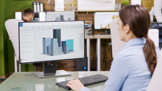 Foto grátis arquiteta feminina fazendo modelos de construção 3d no computador. arquiteto, segurando a planta.