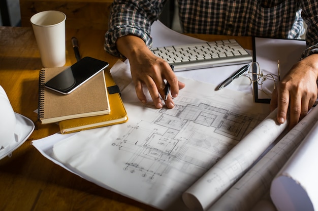 Foto grátis arquiteto criativo que se projeta nos grandes desenhos no escritório ou no café loft escuro com estilo escuro e retro.