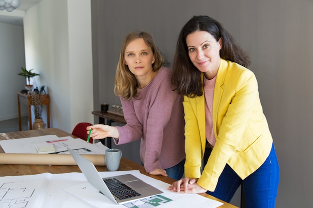 Arquiteto feminino conteúdo e cliente discutindo o projeto da casa