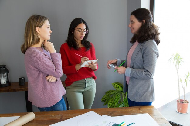 Arquitetos femininos sérios trabalhando e discutindo questões