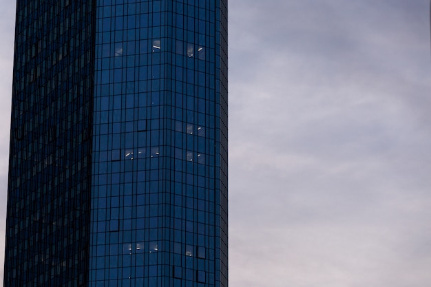 Arranha-céu em uma fachada de vidro sob o céu nublado em Frankfurt, Alemanha