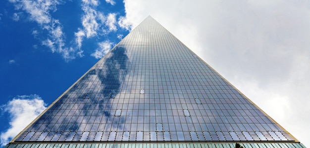 Foto grátis arranha-céu triangular e céu nublado