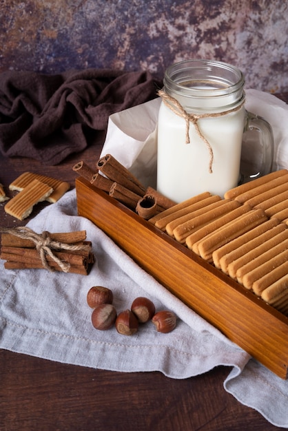 Arranjo de alto ângulo com leite em uma jarra e biscoitos