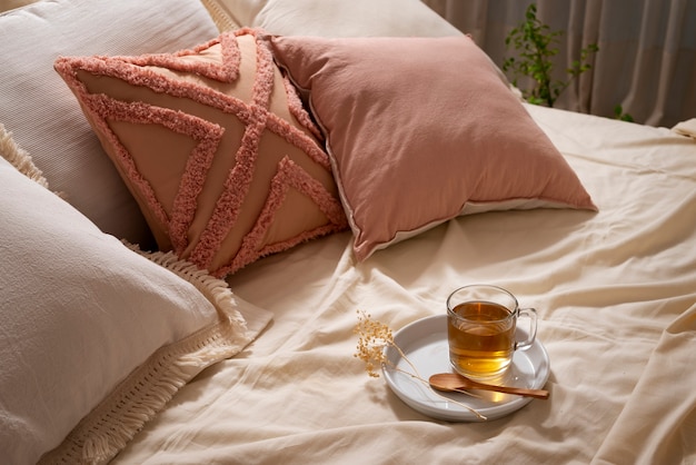 Arranjo de cama aconchegante de alto ângulo com chá