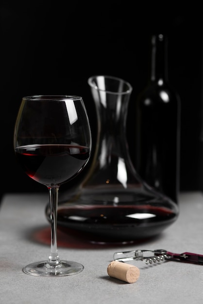 Arranjo de copo, jarra e garrafa de vinho tinto