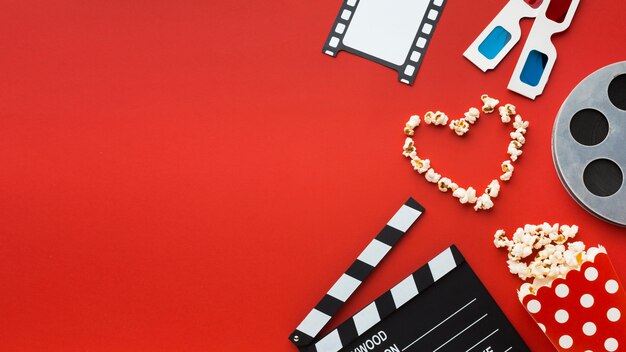 Arranjo de elementos do cinema em fundo vermelho, com espaço de cópia