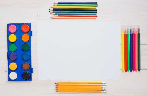 Foto grátis arranjo de equipamentos de pintura e papel branco na mesa