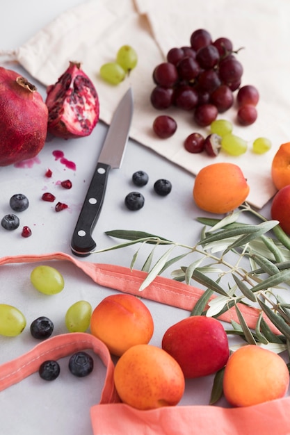 Foto grátis arranjo de folhas e frutas com faca