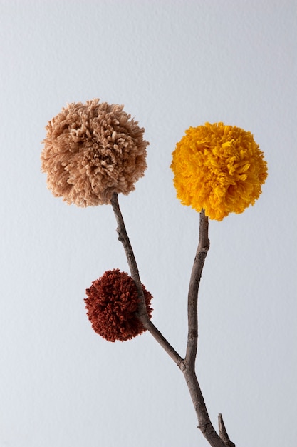 Arranjo de pompons marrom e amarelo