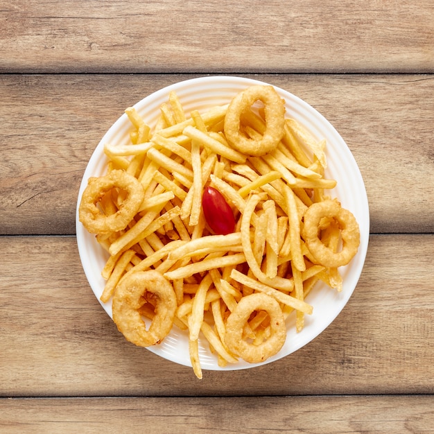 Arranjo de vista superior com batatas fritas e anéis de cebola