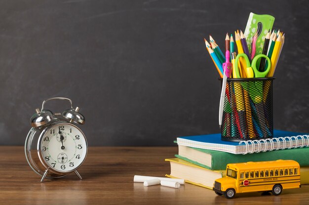 Arranjo do dia da educação em uma mesa com um relógio