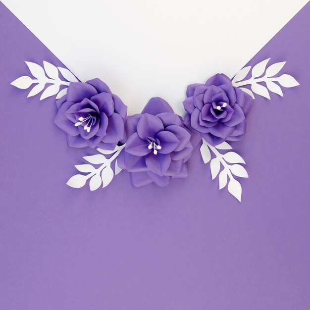 Arranjo liso leigo com flores de papel e fundo roxo