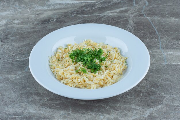 Arroz basmati cozido em um prato, na mesa de mármore.