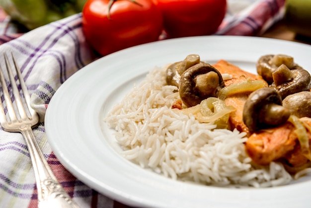 Foto grátis arroz com carne e cogumelos em chapa branca na tovel