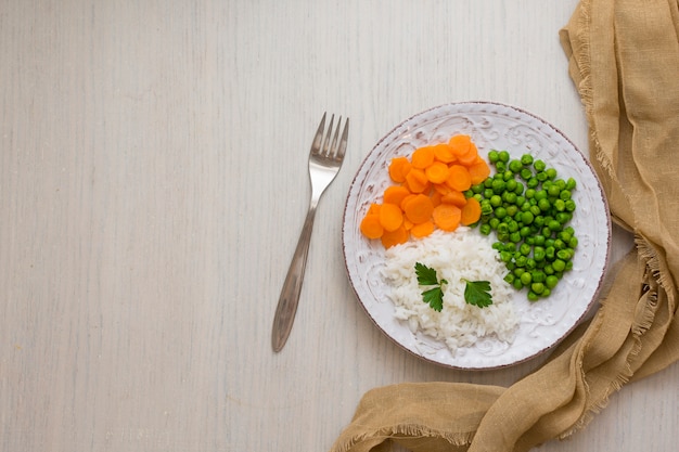 Arroz com legumes e salsa no prato com garfo