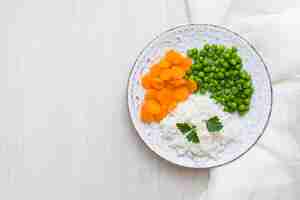 Foto grátis arroz com legumes e salsa verde no prato com pano branco