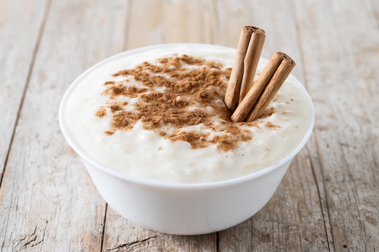 Arroz con leche Arroz doce com canela em tigela sobre mesa de madeira